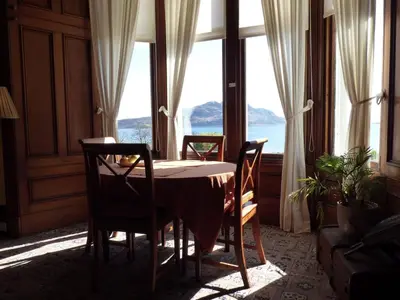 a table and chairs in a room with a large window at Kinneil Self Catering in Lamlash