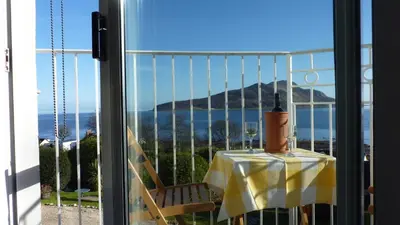 a room with a table and a view of the ocean at Kinneil Self Catering in Lamlash