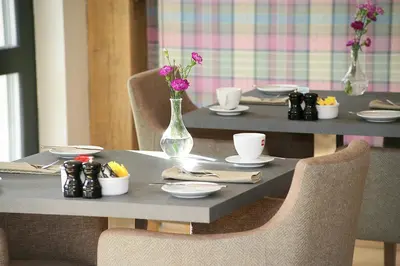 a table with a vase of flowers on it at The Loch Lomond Guesthouse in Balloch
