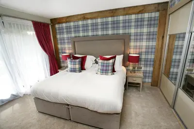 a bedroom with a large white bed with red pillows at The Loch Lomond Guesthouse in Balloch