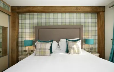 a bedroom with a large bed with two pillows at The Loch Lomond Guesthouse in Balloch