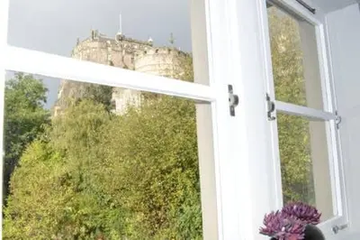 a window with a view of a castle at castle Apartment 1 in Edinburgh