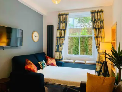a living room with a couch and a window at Grassmarket Jewel in Edinburgh