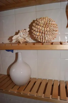 a shelf with a white vase and a flower on it at Shegarton Farm Cottages in Luss