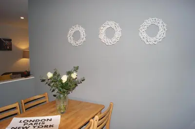 a table with a vase of flowers on a wall at Shegarton Farm Cottages in Luss