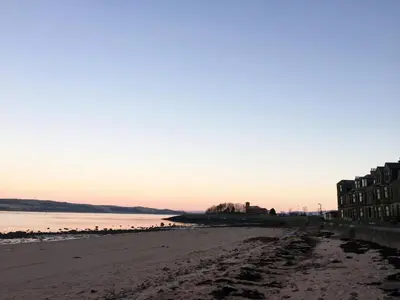 a view of the beach at sunset at Beach House No1 With Amazing Sea Views And Direct Beach Access in Fairlie