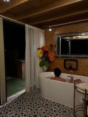 a person sitting in a bath tub in a bathroom at Dunroamin Lodges in Drymen