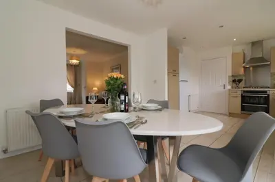 a white dining room with a white table and chairs at Signature - Wilkie House in Holytown