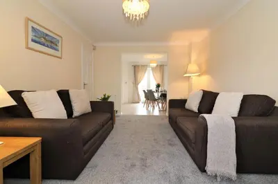 a living room with two brown couches and a table at Signature - Wilkie House in Holytown