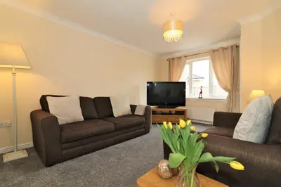 a living room with a couch and a television at Signature - Wilkie House in Holytown