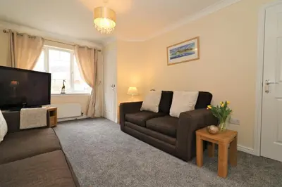 a living room with a couch and a television at Signature - Wilkie House in Holytown