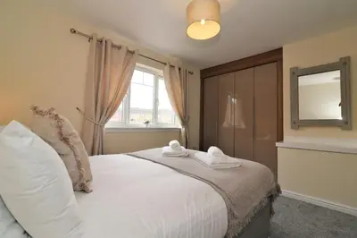a bedroom with a bed with towels on it at Signature - Wilkie House in Holytown