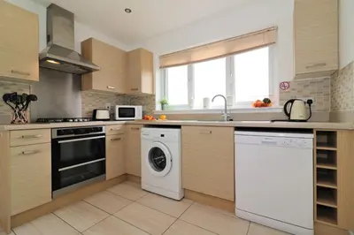 a kitchen with a dishwasher and a washer at Signature - Wilkie House in Holytown