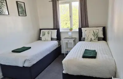 two beds in a small room with a window at Levenhowe Holiday Apartment in Balloch