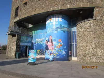 a woman is standing in front of a building at Levenhowe Holiday Apartment in Balloch