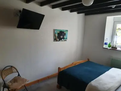 a bedroom with a bed and a tv on the wall at B&B Drum Farm in Stirling