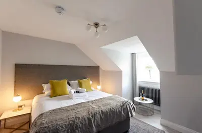 a bedroom with a large bed with yellow pillows at Sweeney Motherwell in Motherwell