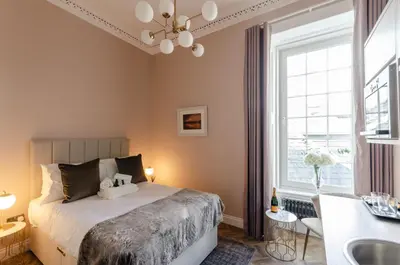 a bedroom with a bed and a sink and a window at Sweeney Motherwell in Motherwell