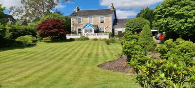 a large house with a large lawn in front of it at CREAG DHUBH COUNTRY HOUSE in Inveraray