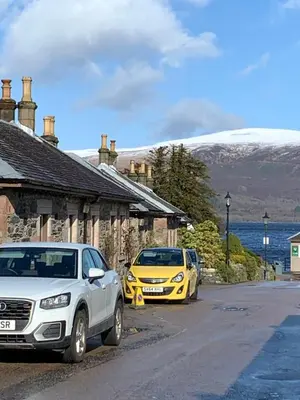 two cars parked in front of a house at Fab-u-Luss in Luss