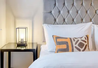 a bedroom with a bed and a night stand with a lamp at The Gloucester Lane Residence in Edinburgh