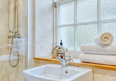 a bathroom with a sink and a window and towels at The Gloucester Lane Residence in Edinburgh