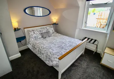 a small bedroom with a bed and a window at Hunters Guest House in Brodick