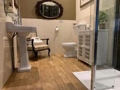 a bathroom with a sink and a toilet and a mirror at Hunters Guest House in Brodick