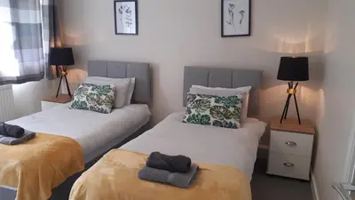 a bedroom with two beds with towels on them at Carvetii - Clark House - Spacious ground floor flat in Rosyth