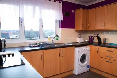 a kitchen with a washer and a washing machine at Carvetii - Derwent House - Spacious 2nd floor flat in Grangemouth