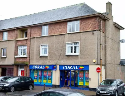 a building with a corral sign on the side of it at Carvetii - Derwent House - Spacious 2nd floor flat in Grangemouth