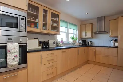 a kitchen with wooden cabinets and a microwave at Sanaigmore Cottage in Port Charlotte