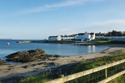 a view of a beach with houses and the ocean at Sanaigmore Cottage in Port Charlotte