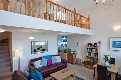 a living room with a couch and a staircase at Kilchoman in Port Charlotte