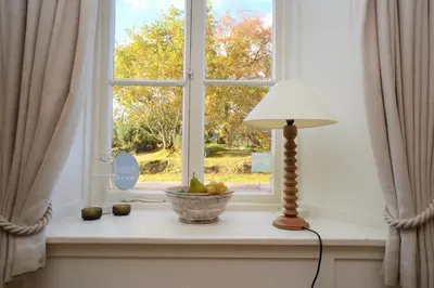a window with a lamp and a bowl of fruit on a window sill at Darroch Beag in Saint Catherines