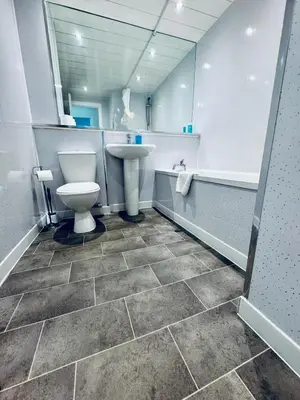 a bathroom with a toilet and a sink and a tub at Modern 2 bedroom Apartment Near City Centre in Glasgow