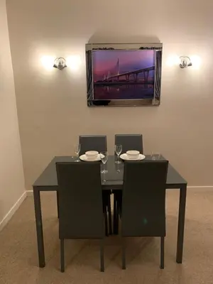 a dining room table with two chairs and a tv on the wall at Dunfermline GF flat, 5 min walk to Train St. and High St. in Dunfermline