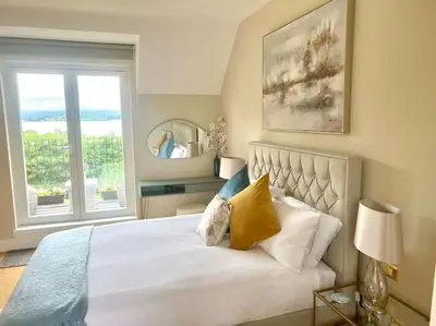 a bedroom with a large bed with a window at Loch View at Lomond Castle in Balloch