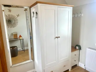 a white cabinet in a room with a mirror at Loch View at Lomond Castle in Balloch