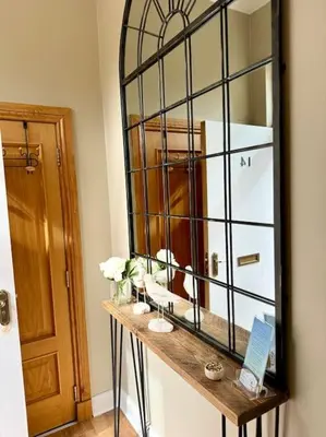 a mirror sitting on top of a wooden table in a room at Loch View at Lomond Castle in Balloch