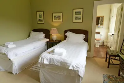 a bedroom with two beds with white sheets at Chesthill House and Estate, Glen Lyon in Aberfeldy