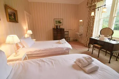 a hotel room with two beds and a desk at Chesthill House and Estate, Glen Lyon in Aberfeldy