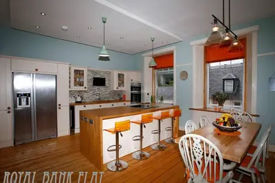 a kitchen with a wooden table and a counter top at Royal Bank Flat in Oban