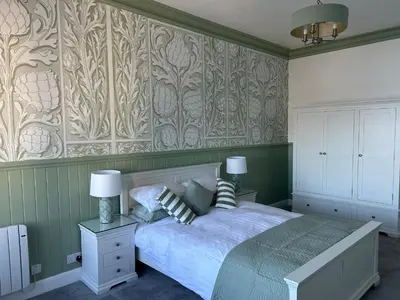 a bedroom with a bed and a wall with patterns at Royal Bank Flat in Oban