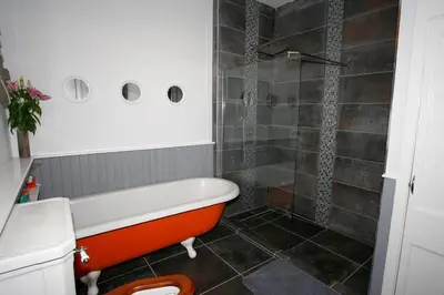 an orange bath tub in a bathroom with a shower at Royal Bank Flat in Oban