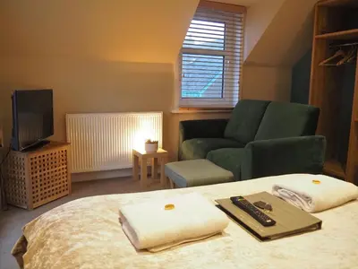 a bedroom with a bed and a couch and a television at Argyll Hotel in Bellochantuy