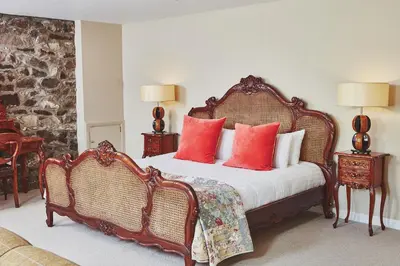 a bedroom with a large bed with red pillows at Brambles of Inveraray in Inveraray