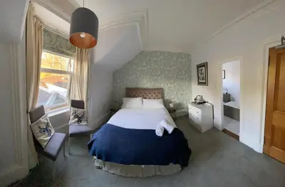 a bedroom with a large bed and a window at The Colintraive in Colintraive