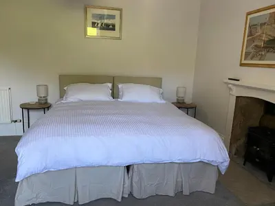 a bedroom with a large bed with white sheets at The Colintraive in Colintraive