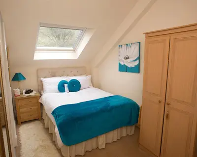 a bedroom with a bed with a blue stuffed animal on it at Craig Park House in Airdrie